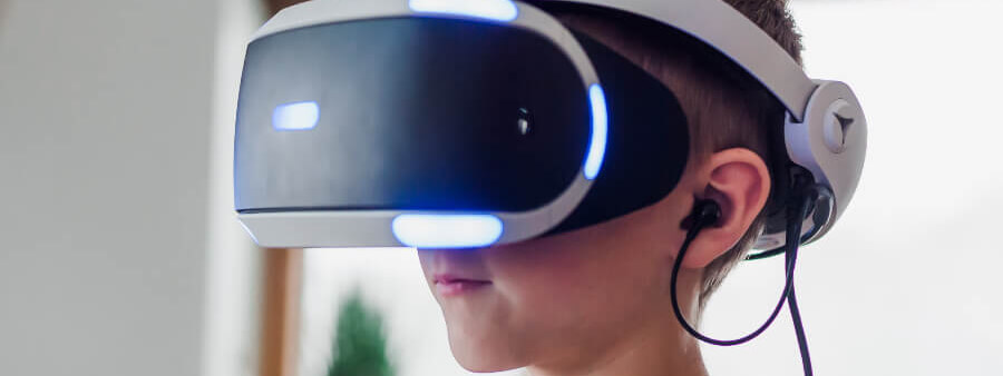 Fotografia de um garoto utilizando óculos de realidade virtual para entrar no Metaverso.