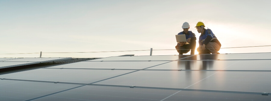energia renovável: dois homens ao lado de painéis solares