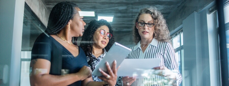 soluções inovadoras: três mulheres em escritório de empresa
