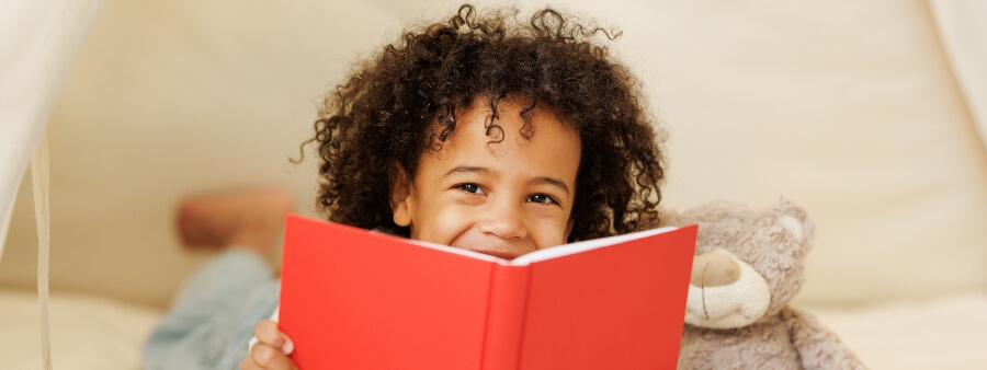 literatura infantojuvenil: criança com livro vermelho