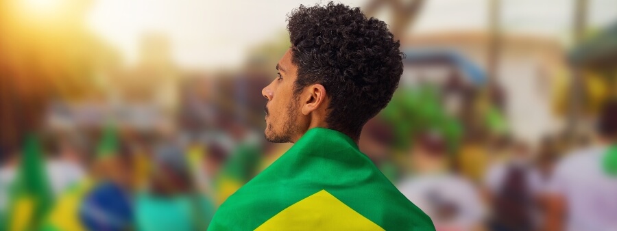 direito de nacionalidade: homem de costas coberto com bandeira do Brasil