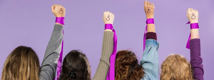 voto feminino no Brasil: 4 mulheres de braços erguidos e punhos cerrados
