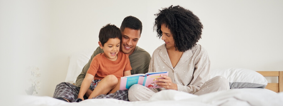 Histórias para dormir: pais lendo para criança na cama