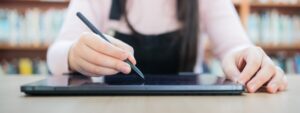 Tecnologia e educação: pessoa escrevendo em tablet