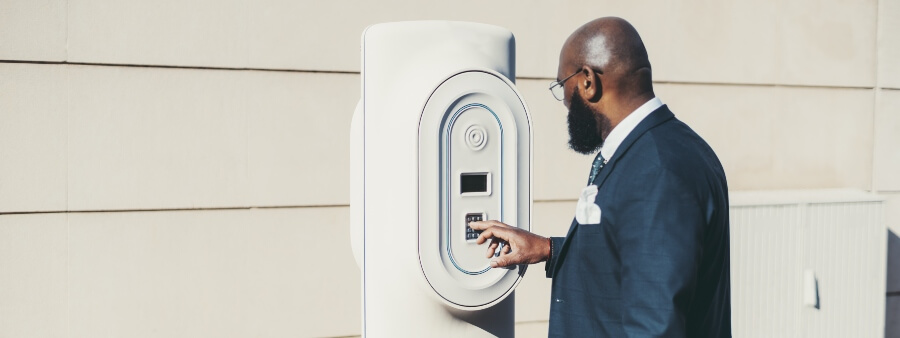 Carregador de carro elétrico em condomínio: homem usando carregador de carro