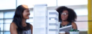 Cuidados ao comprar imóvel na planta: duas pessoas com maquete de prédio