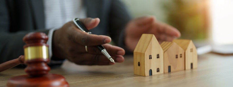 Cadastro Imobiliário Brasileiro: mãos sobre miniatura de imóvel