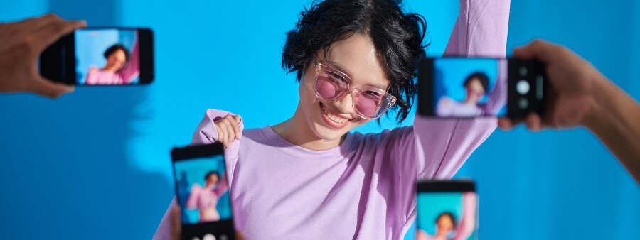 como funciona o algoritmo do tiktok: blogueira posando para celulares